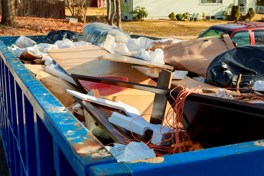 blue dumpster close up full of junk at property exteriors des moines ia
